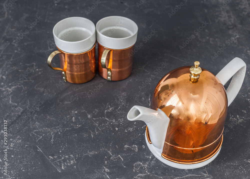 Wall mural white and bronze coffee pot on black rustic background table