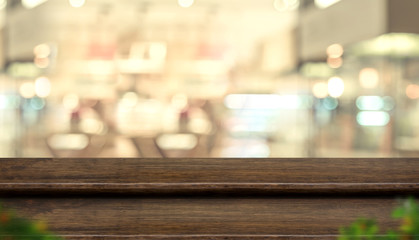 Empty step dark wood table top food stand with blur people in coffee shop background bokeh light.Mock up for display or montage of product,Banner for advertise on online media,business presentation