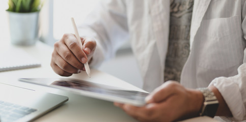 Cropped shot of young freelancer writing his idea concept on tablet for his upcoming project