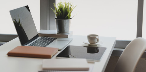 Comfortable home-office corner with laptop computer, tablet and office supplies with coffee cup