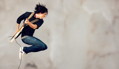 Man jumping with guitar, inspired guitarist