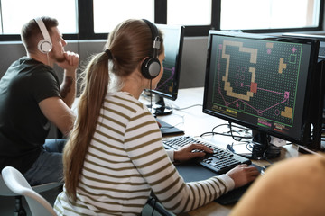 Woman playing video game in internet cafe