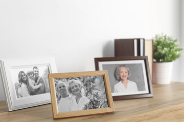 Framed photos on cabinet near white wall