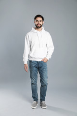 Full length portrait of young man in sweater on grey background. Mock up for design