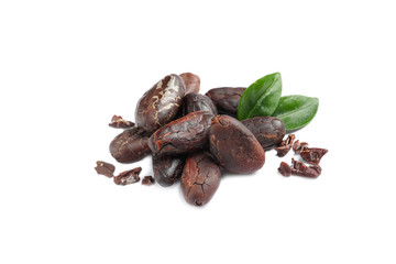 Pile of aromatic cocoa beans with leaves isolated on white
