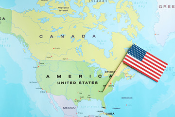 Little national flag near USA on world map, top view