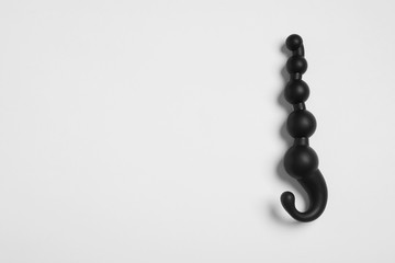 Black anal beads on white background, top view. Sex toy
