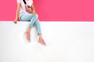 Woman wearing stylish shoes on color background, closeup