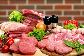Fresh raw meat background with vegetables on wooden desk isolated on white background