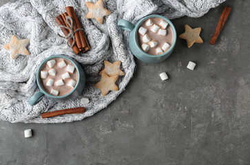 Composition with delicious hot cocoa drink and cookies on dark grey background, flat lay
