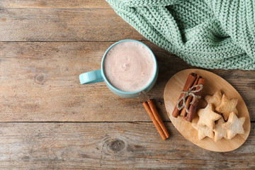 Composition with delicious hot cocoa drink and cookies on wooden background, flat lay