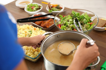 Volunteer serving food to poor people in charity centre, closeup