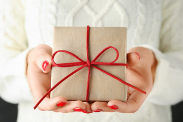 Woman holding beautiful Christmas gift with bow, closeup