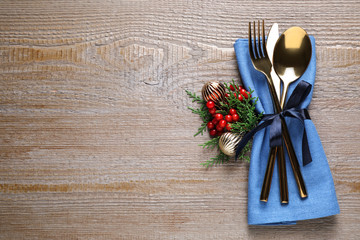 Cutlery set on wooden table, top view with space for text. Christmas celebration