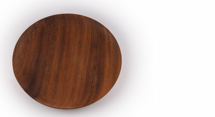 Round wooden plate on white background, view from above.