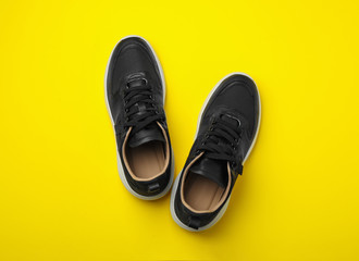 Pair of stylish shoes on yellow background, top view