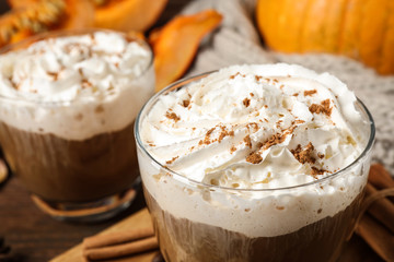 Glass with tasty pumpkin spice latte on table, closeup