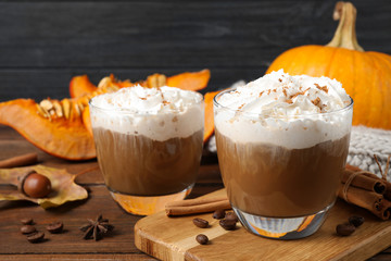 Glasses with tasty pumpkin spice latte on wooden table