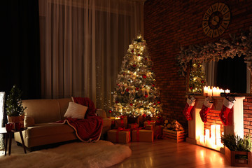 Stylish room interior with beautiful Christmas tree in evening