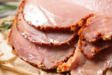 Slices of delicious cooked ham on parchment, closeup