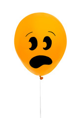 Orange balloon with drawing of scared face on white background. Halloween party