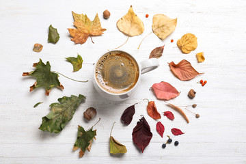 Flat lay composition with cup of hot drink on white wooden table. Cozy autumn atmosphere