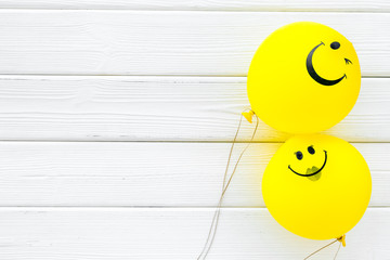 Happiness emotion. Yellow balloon with smile on white wooden background top view space for text