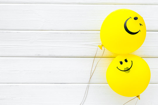 Happiness emotion. Yellow balloon with smile on white wooden background top view space for text