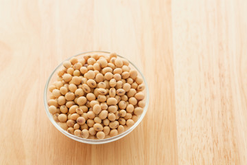 Soybeans are in a cup, placed on a wooden table with copy space,Dry bean yellow  color