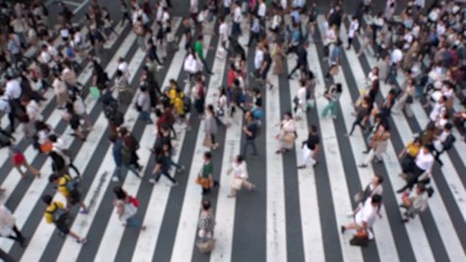 UMEDA, OSAKA, JAPAN - CIRCA SEPTEMBER 2019 : Aerial blurred view of zebra crossing near Osaka train station. Crowd of people at the street. Shot in busy rush hour. Slow motion.