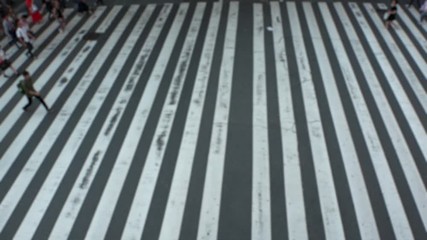 UMEDA, OSAKA, JAPAN - CIRCA SEPTEMBER 2019 : Aerial blurred view of zebra crossing near Osaka train station. Crowd of people at the street. Shot in busy rush hour. Slow motion.