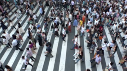 UMEDA, OSAKA, JAPAN - CIRCA SEPTEMBER 2019 : Aerial blurred view of zebra crossing near Osaka train station. Crowd of people at the street. Shot in busy rush hour. Slow motion.