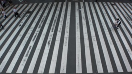 UMEDA, OSAKA, JAPAN - CIRCA SEPTEMBER 2019 : Aerial blurred view of zebra crossing near Osaka train station. Crowd of people at the street. Shot in busy rush hour. Slow motion.