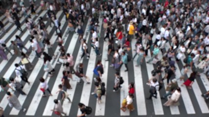 UMEDA, OSAKA, JAPAN - CIRCA SEPTEMBER 2019 : Aerial blurred view of zebra crossing near Osaka train station. Crowd of people at the street. Shot in busy rush hour. Slow motion.