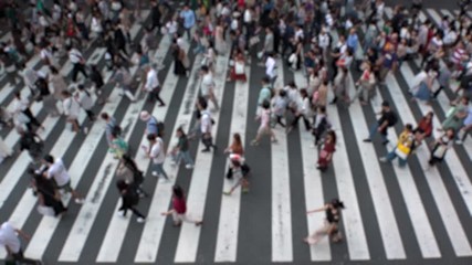 UMEDA, OSAKA, JAPAN - CIRCA SEPTEMBER 2019 : Aerial blurred view of zebra crossing near Osaka train station. Crowd of people at the street. Shot in busy rush hour. Slow motion.