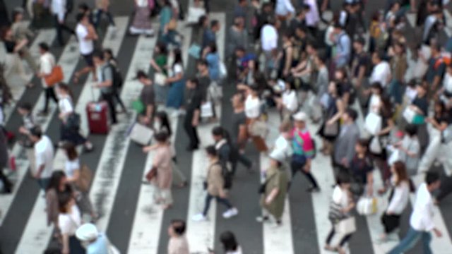UMEDA, OSAKA, JAPAN - CIRCA SEPTEMBER 2019 : Aerial blurred view of zebra crossing near Osaka train station. Crowd of people at the street. Shot in busy rush hour. Slow motion.