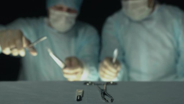 Surgeons take instruments and begin operation or procedure. Out of focus for background. Doctors with scalpel, grasper or forcep are ready to start cut a patient's tissues in hospital.