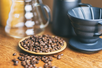 Closeup image of coffee bean and coffee drip set on wooden table