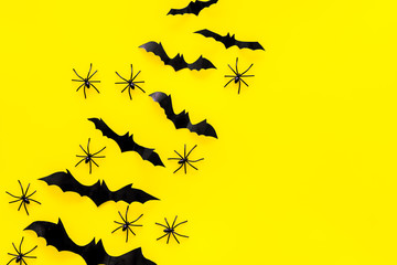 Stylish Halloween design. Bats and spiders on yellow background top view copy space