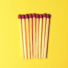 Symbol of danger with matches on yellow  background top view , pile of match arrange in a row , unlit matches 