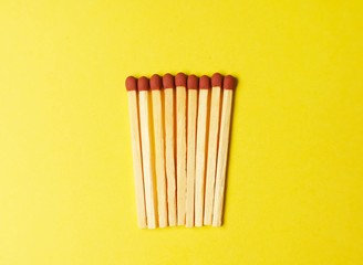 Symbol of danger with matches on yellow  background top view , pile of match arrange in a row , unlit matches 