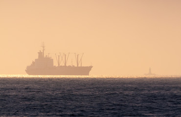 Ship on the roadstead and a lighthouse in the evening twilight. Vladivostok. Russia.