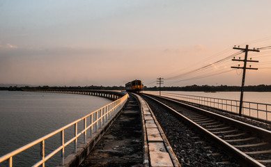  A running train on railroad tracks in dam.