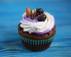 delicious cupcake with delicate cream and berries, close up
