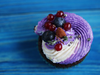 delicious cupcake with delicate cream and berries, close up