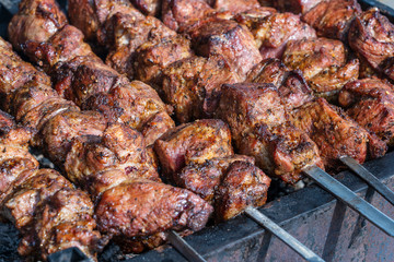 Grilled kebab cooking on metal skewer closeup. Roasted meat cooked at barbecue. BBQ fresh beef meat chop slices. Traditional eastern dish, shish kebab