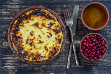 Sweet cottage cheese casserole with raisins and semolina on wooden table. Ceramic bowl with baked cottage cheese casserole , closeup, top view