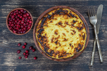 Sweet cottage cheese casserole with raisins and semolina on wooden table. Ceramic bowl with baked cottage cheese casserole , closeup, top view