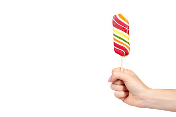Hand with striped color lollipop, bright cool candy.