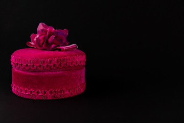 Obraz na płótnie Canvas Pink round gift box with ribbon isolated on a dark background